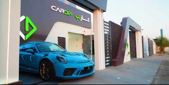 واجهة استوديو كاردب نهاراً وأمامها سيارة بورشه زرقاء